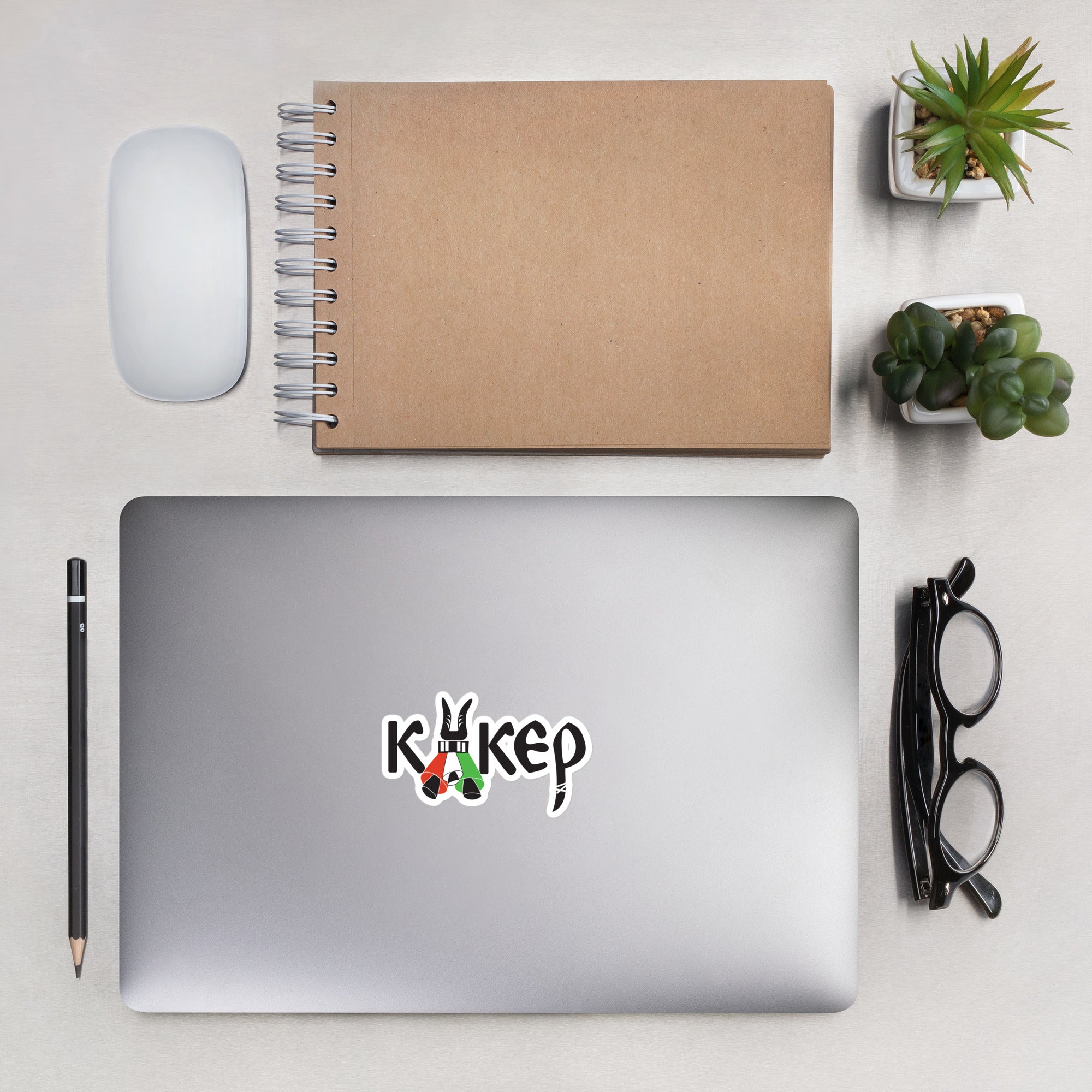 Bulgarian kuker vinyl sticker, stylized with kuker bells. Mockup on laptop with spiral notebook and accessories.