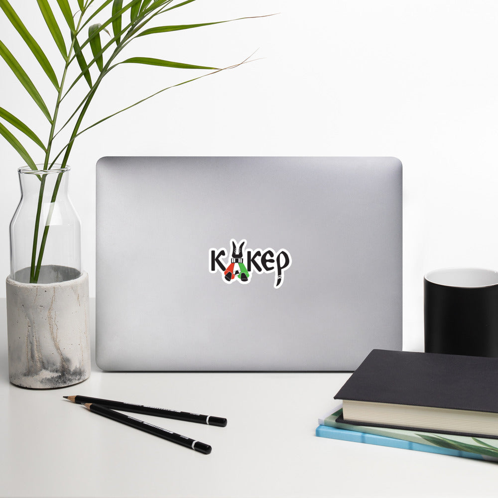 Bulgarian kuker vinyl sticker, stylized with kuker bells. Mockup on laptop with plant, book, and accessories.