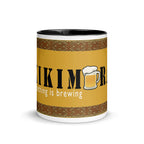 White ceramic mugs with color inside and saying "Kikimora Something is brewing." Referencing the Slavic folklore tales that the swamp creature brews beer.