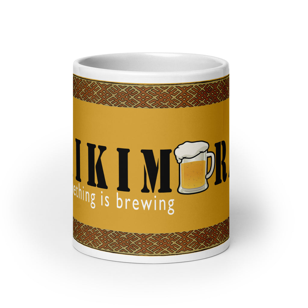 Front view of white ceramic mug with saying "Kikimora Something is brewing." Referencing the Slavic folklore tales that the swamp creature brews beer.