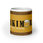 Front view of white ceramic mug with saying "Kikimora Something is brewing." Referencing the Slavic folklore tales that the swamp creature brews beer.